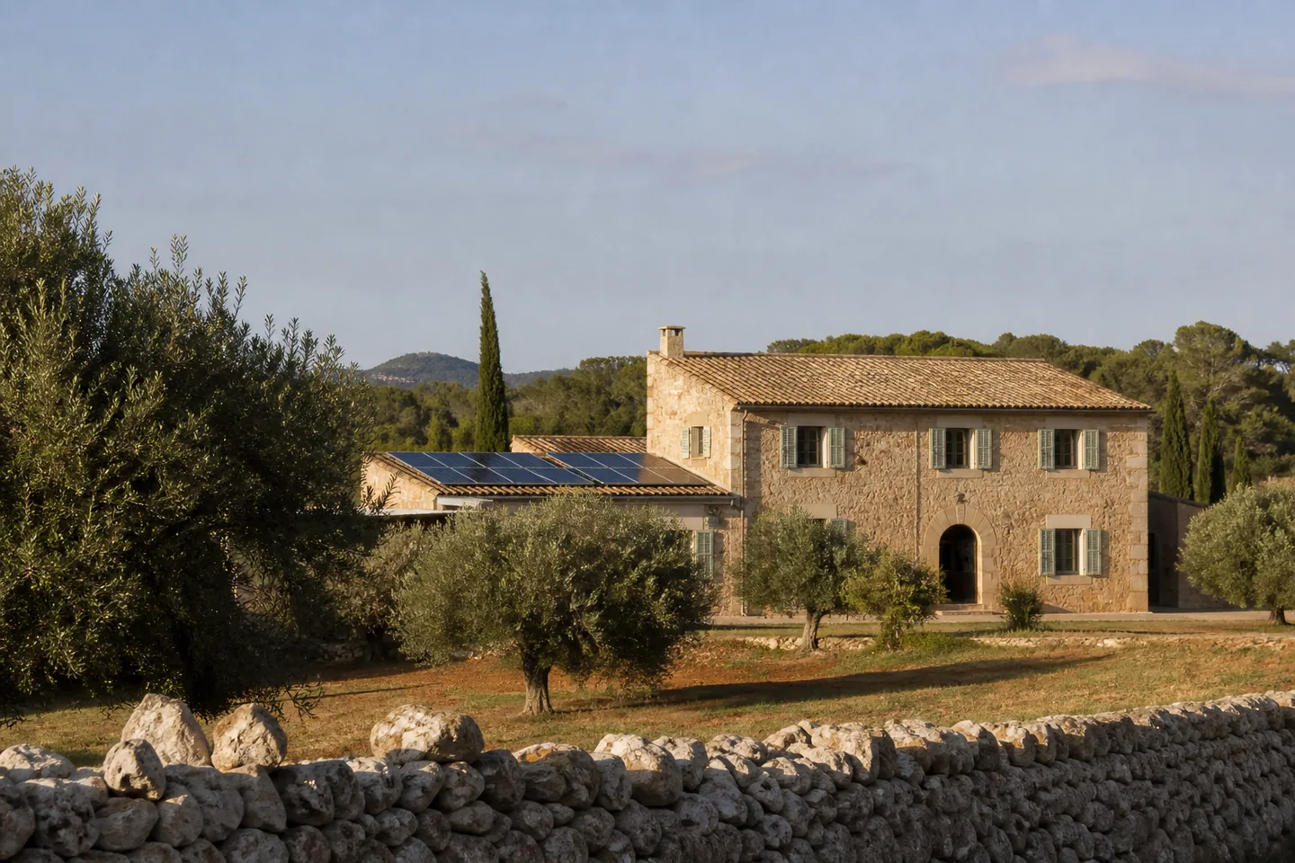 Traditional stone finca with solar panels on an adjoining roof